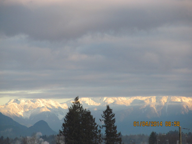 Looking north at distant sunlit snow Surrey, British Columbia Canada