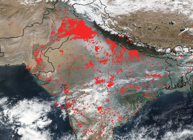 Satellite image shows smoke from fires (indicated by red dots) over ...