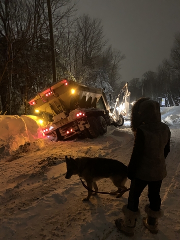 a snow removal truck slides in a ditch. Sainte-Anne-des-Lacs, Quebec, CA