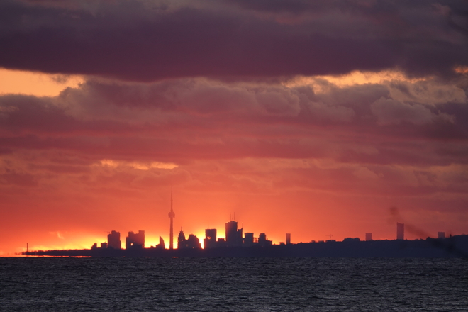 The Sun appears to set behind the CN Tower as viewed from Bonnie Brea Point South Oshawa, Ont.