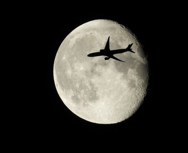 Plane flying across the moon Eskasoni, Nova Scotia